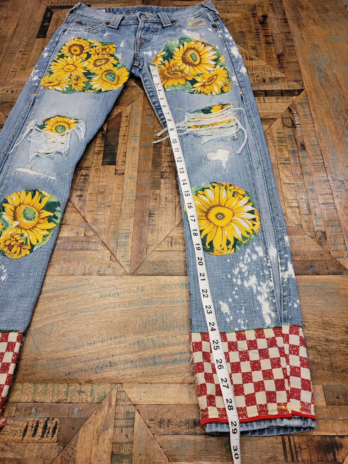 a pair of jeans with sunflowers on them.