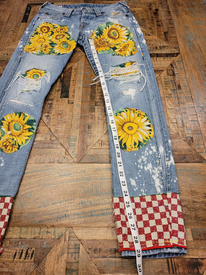 a pair of jeans with sunflowers on them.