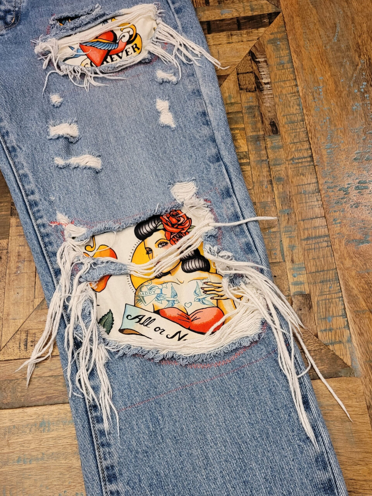 a pair of ripped jeans with patches on them.