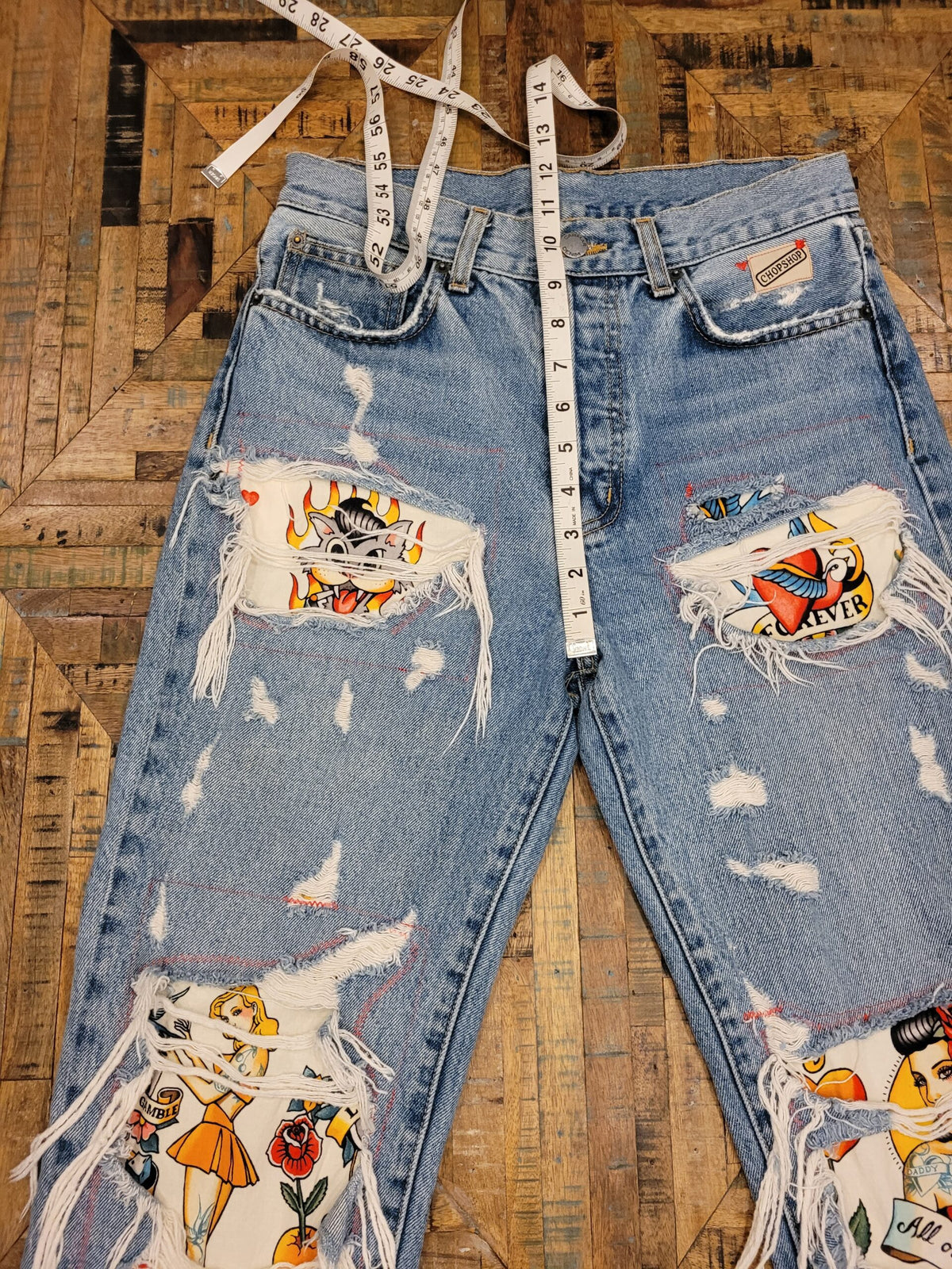 a pair of ripped jeans with a tape measure.