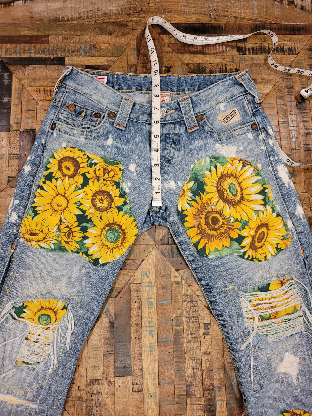 a pair of jeans with sunflowers on them.