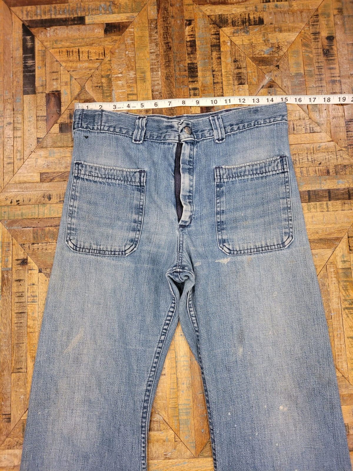 a pair of blue jeans on a wooden floor.