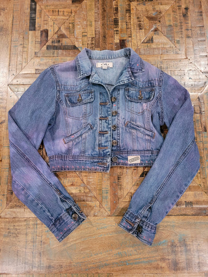 a women's denim jacket on a wooden floor.