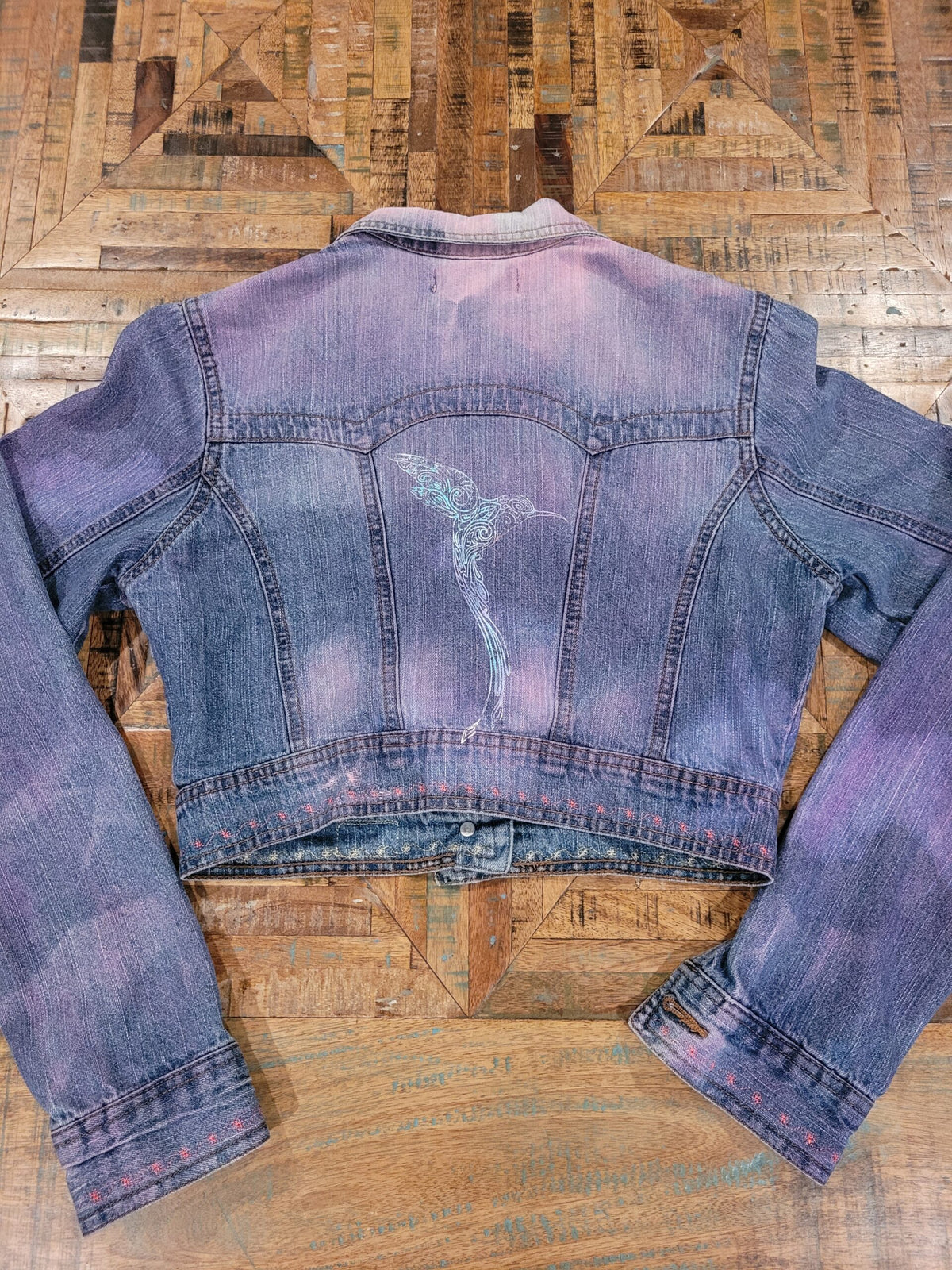 a blue and purple denim jacket on a wooden table.