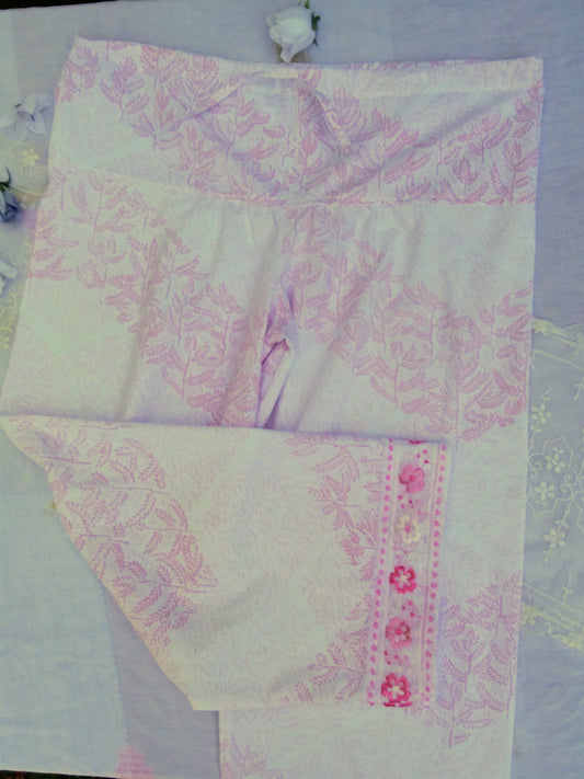 Pink and white palazzo pants with vintage lace cuffs on a table