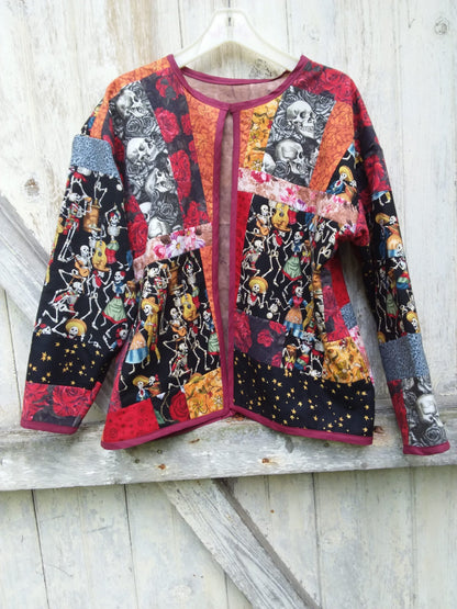 A black and red quilted jacket hanging on a wooden wall.