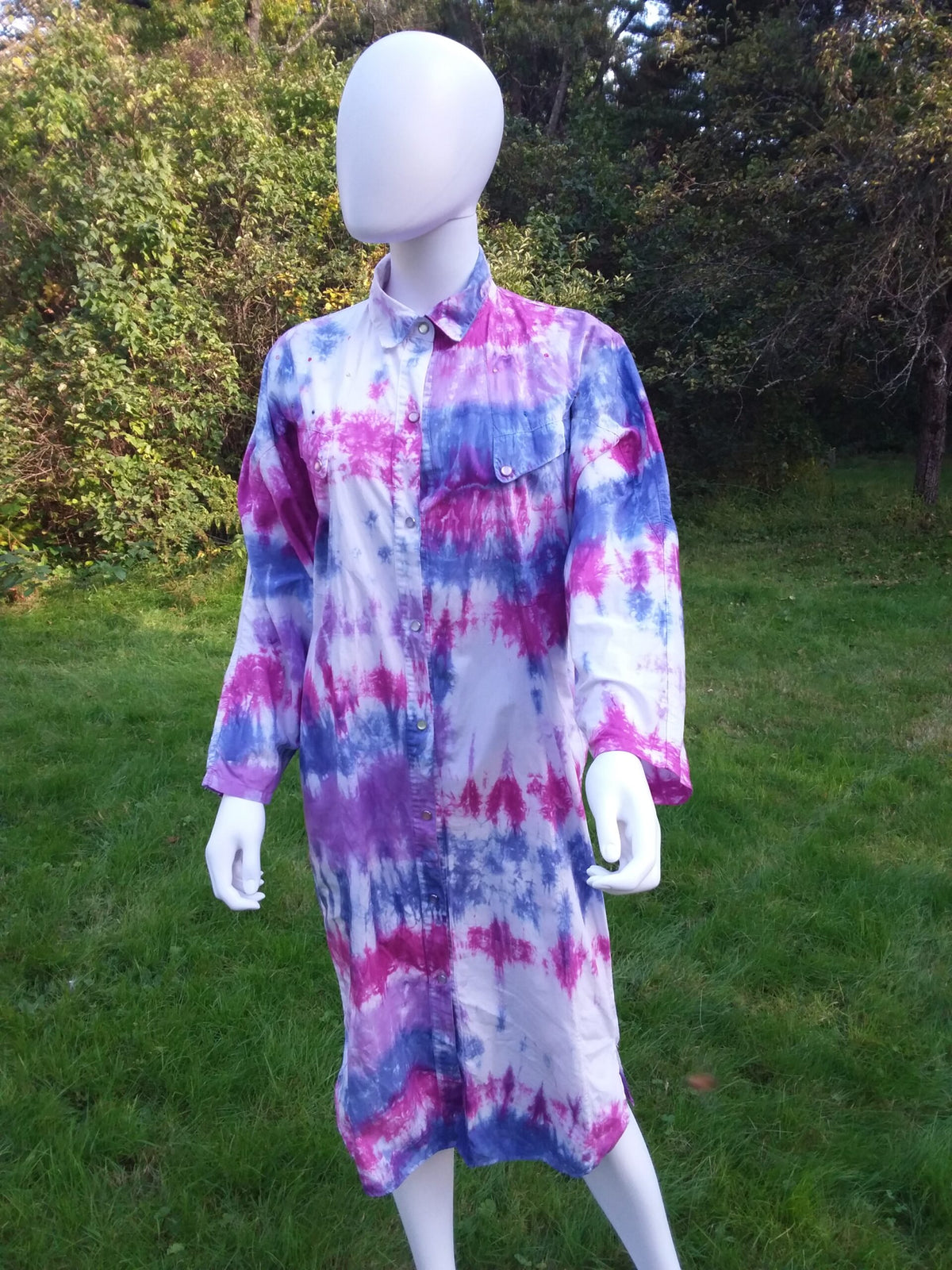 A tie dye upcycled duster dress in shades of pink, blue and purple.