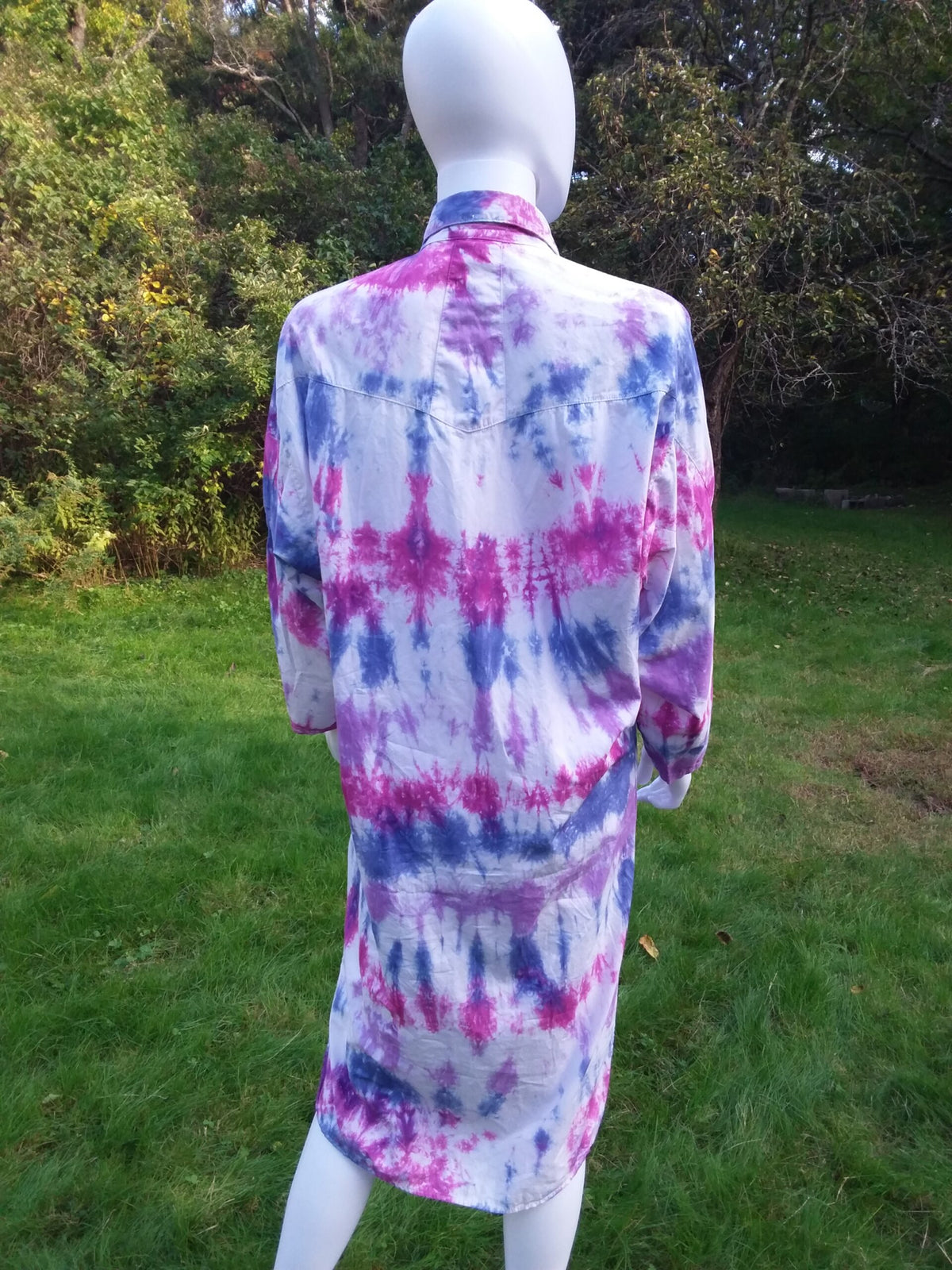 A long tie dye dress with purple, pink and blue colors across the back.