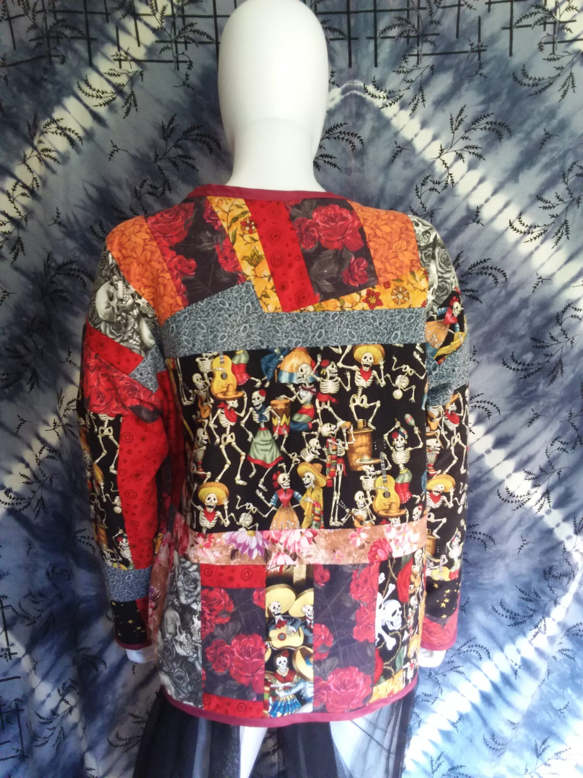 A mannequin mannequin wearing a colorful patchwork jacket.
