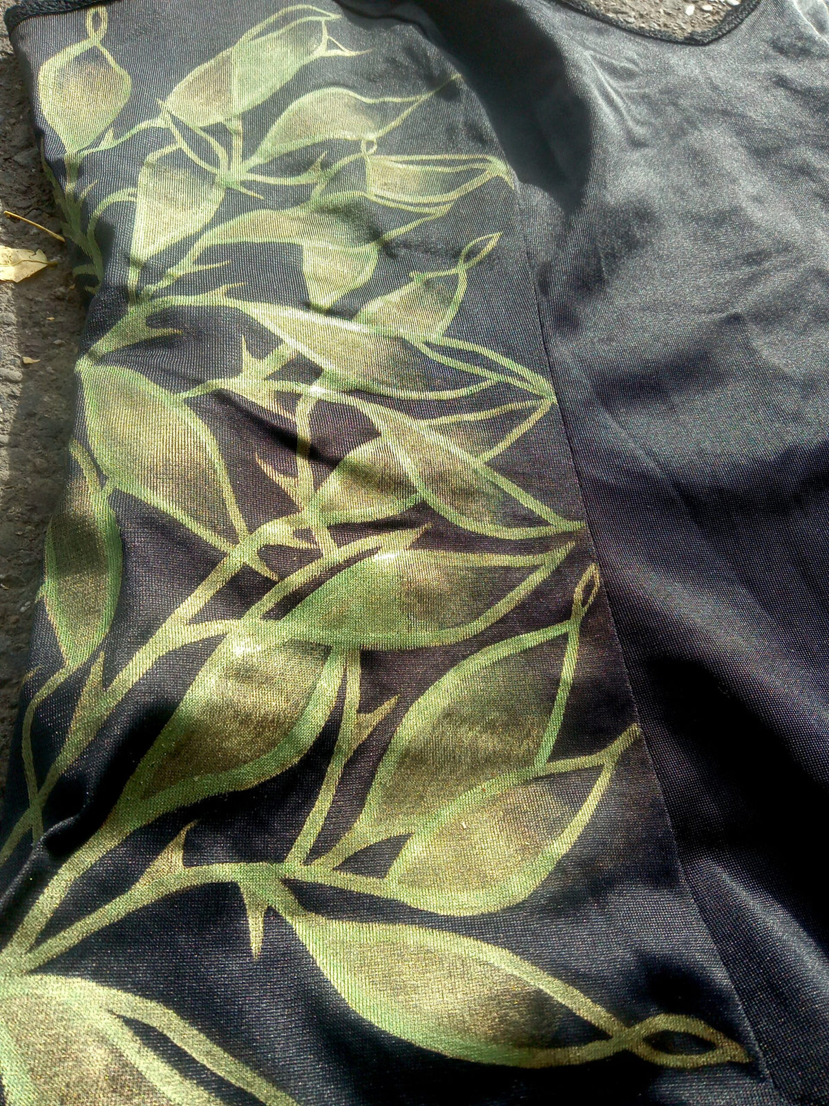 A black shirt with green leaves on it.