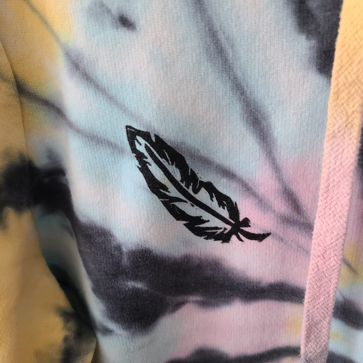 A tie dye hoodie with a feather on it.