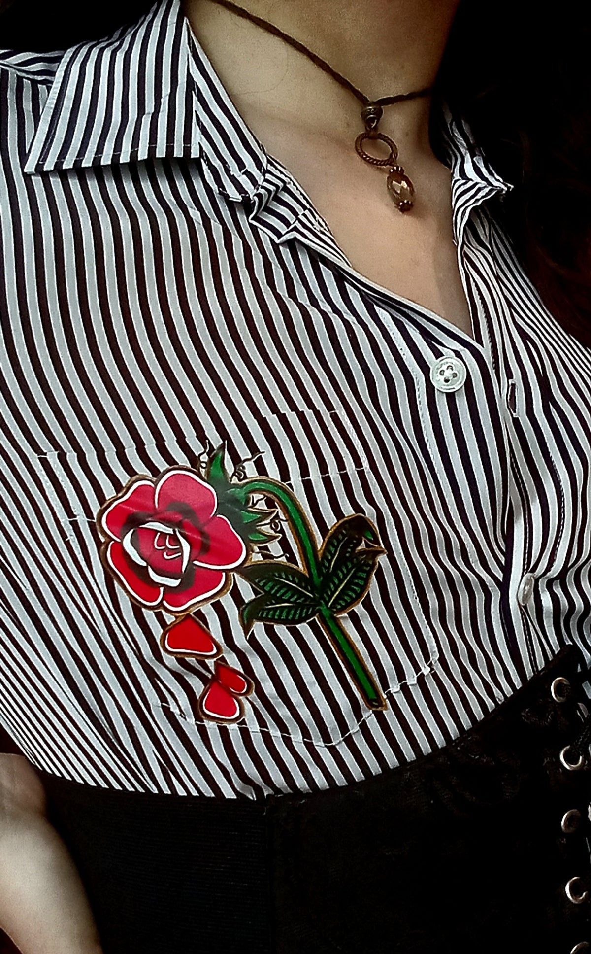 A woman wearing a black and white shirt with a rose on it.