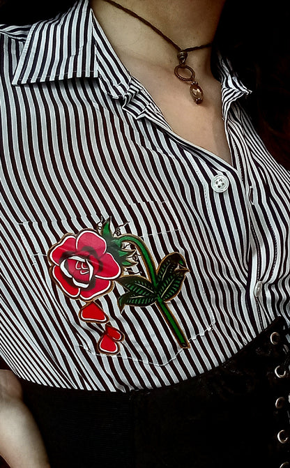 A woman wearing a black and white shirt with a rose on it.