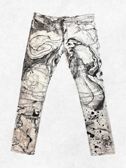 A pair of jeans with black and white paint on them.
