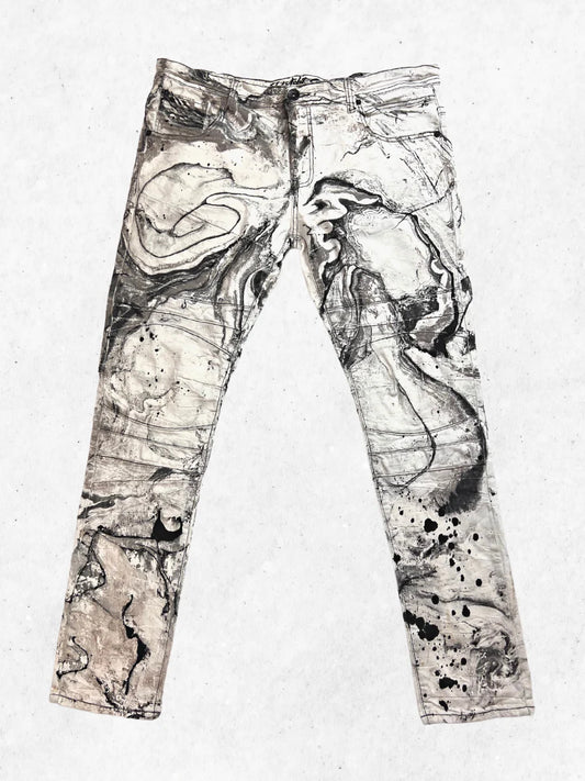 A pair of jeans with black and white paint on them.