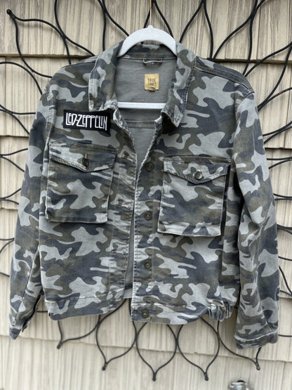 a camouflage jacket hanging on a wall.