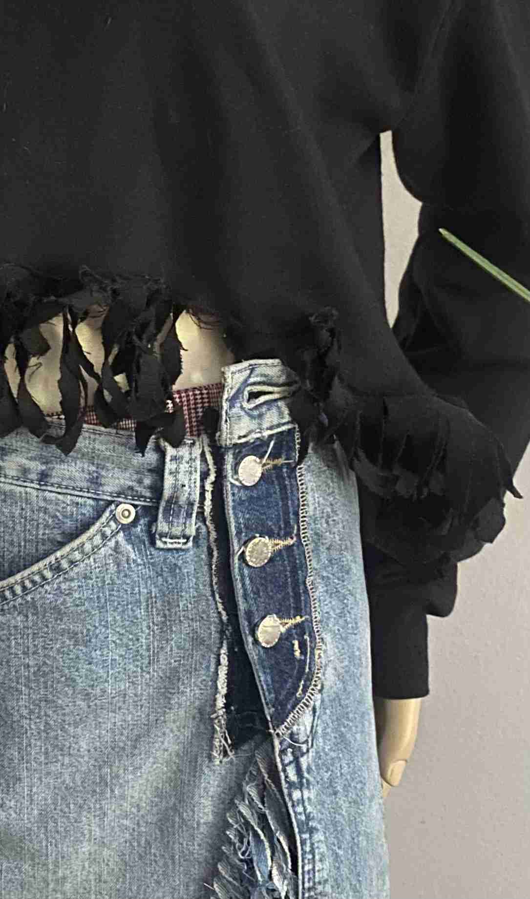 a mannequin wearing a black shirt and jeans.