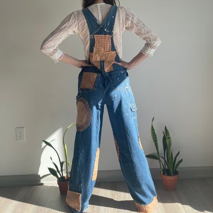 A woman wearing denim overalls with patches.