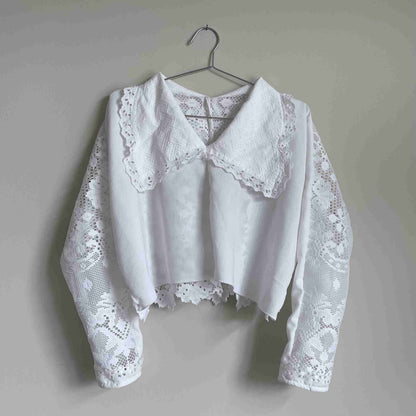 a white blouse hanging on a wall.