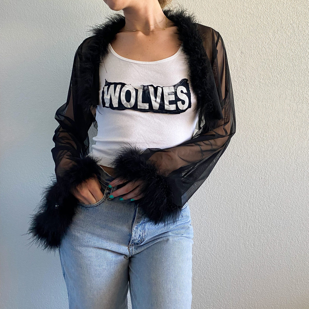 A woman wearing a 1of1 wolves tank top with a slogan on it.