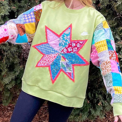 a woman wearing a green sweatshirt with a patchwork star on it.