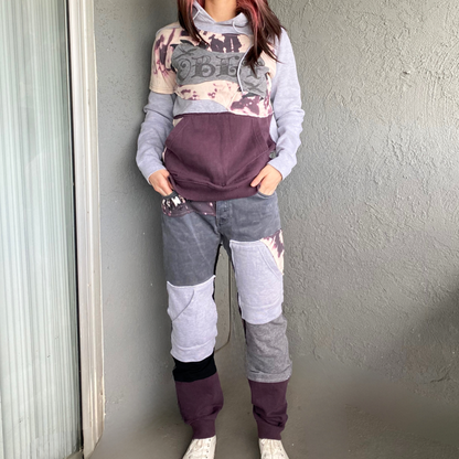 A woman wearing a purple hoodie and sweatpants.