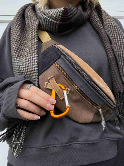 a woman holding a purse with a pair of scissors in it.
