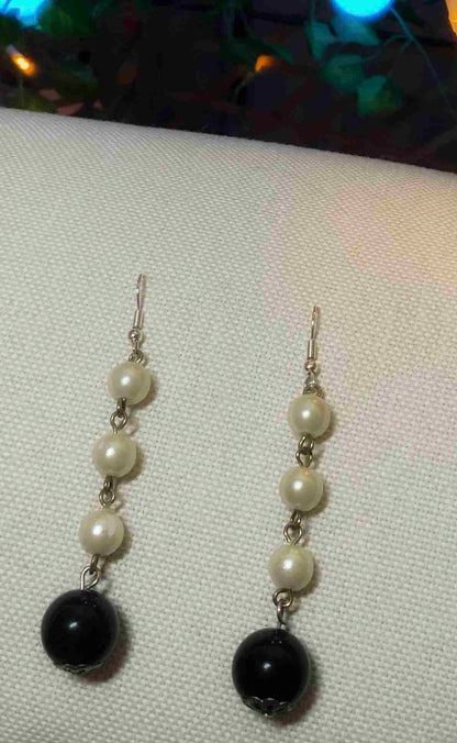 a pair of black and white earrings.