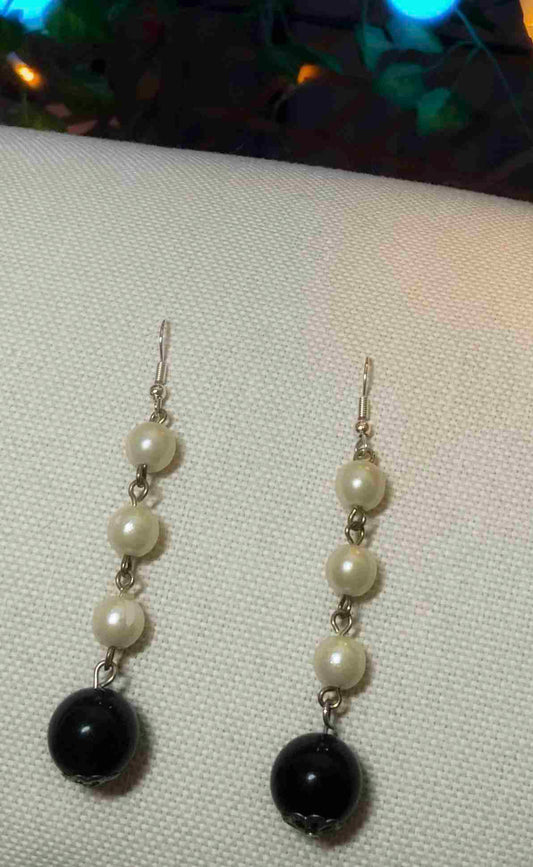 a pair of black and white earrings.