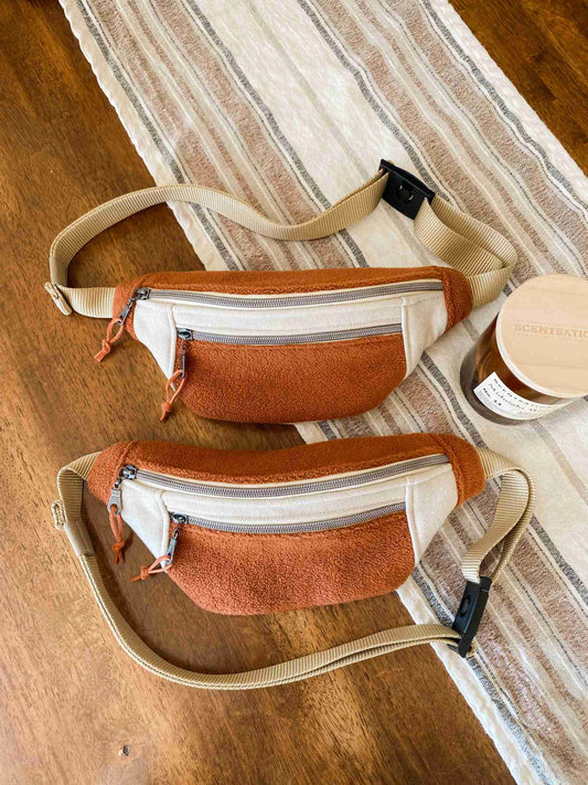 two brown and white bags sitting on top of a wooden floor.
