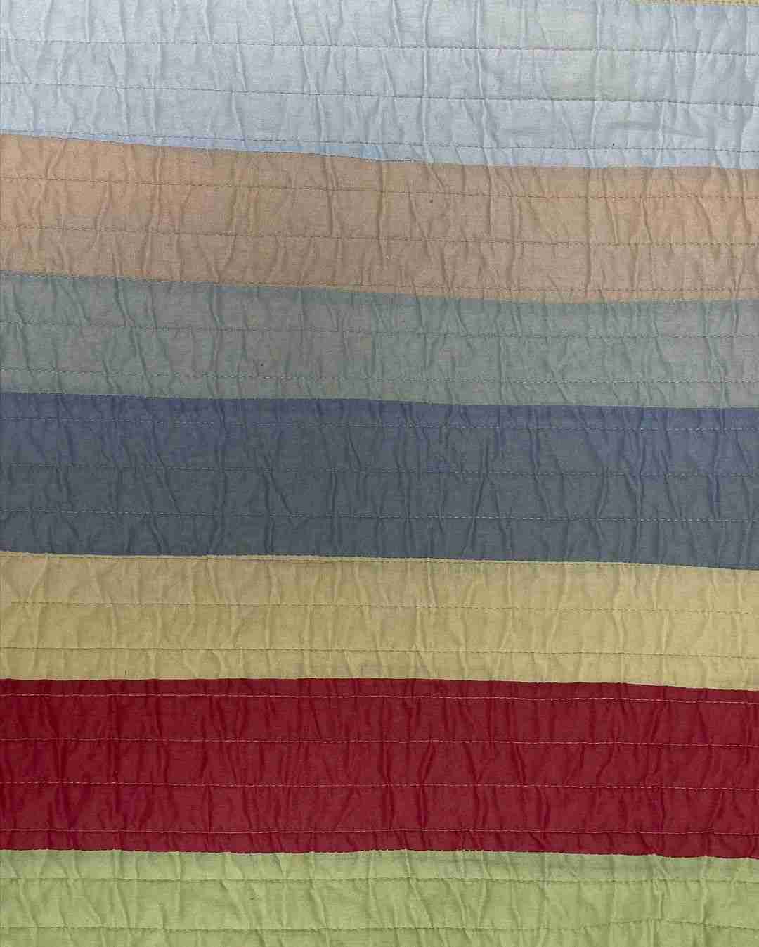 a large multicolored quilt on a bed.
