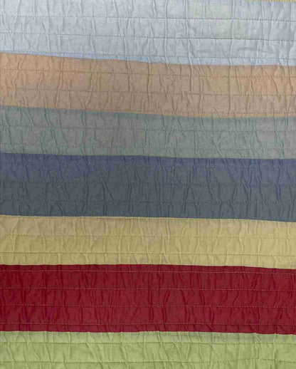 a large multicolored quilt on a bed.