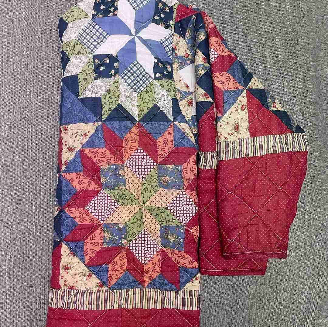 a red, white and blue quilt on a hanger.