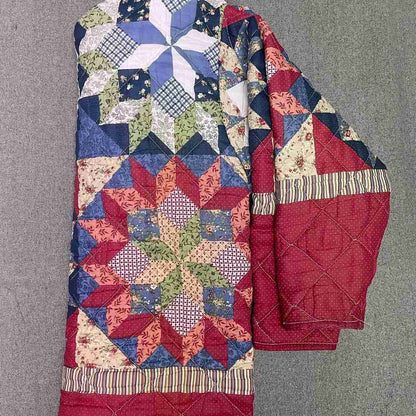 a red, white and blue quilt on a hanger.