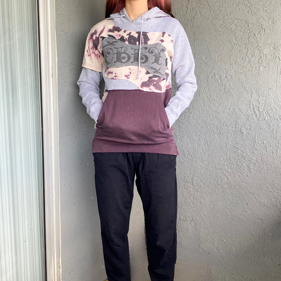 A woman wearing a purple hoodie and black pants.
