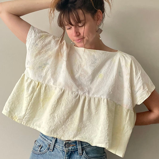 A woman wearing a Yellow Tie-dyed Babydoll Crop Top and jeans.