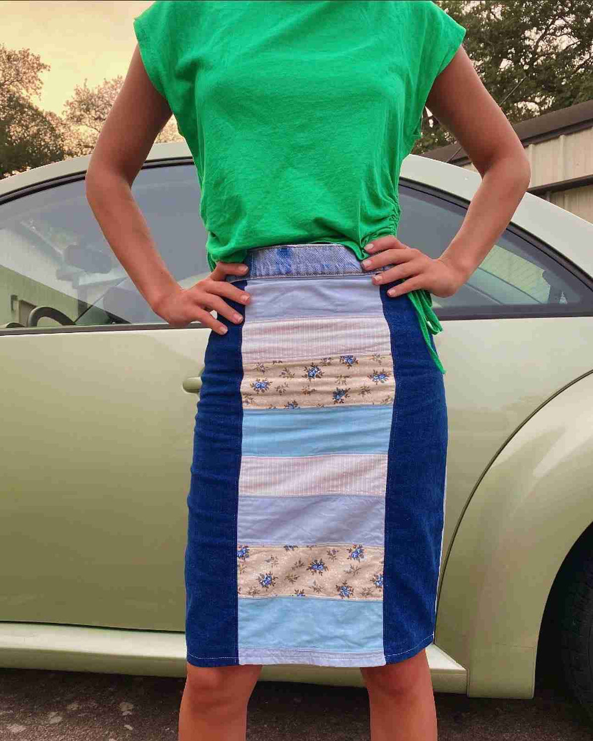 a woman standing in front of a car with her hands on her hips.