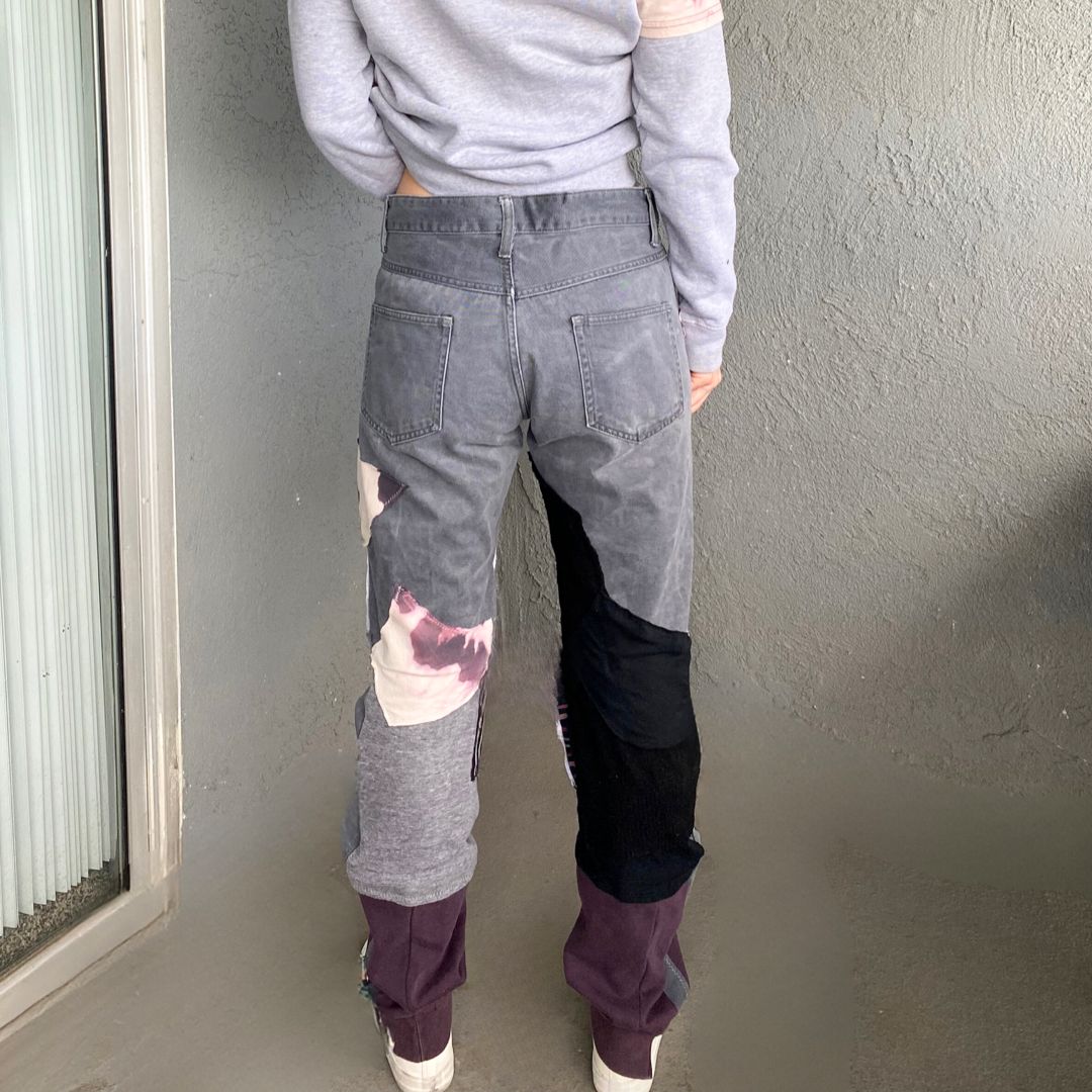 The back view of a woman wearing a pair of grey pants.