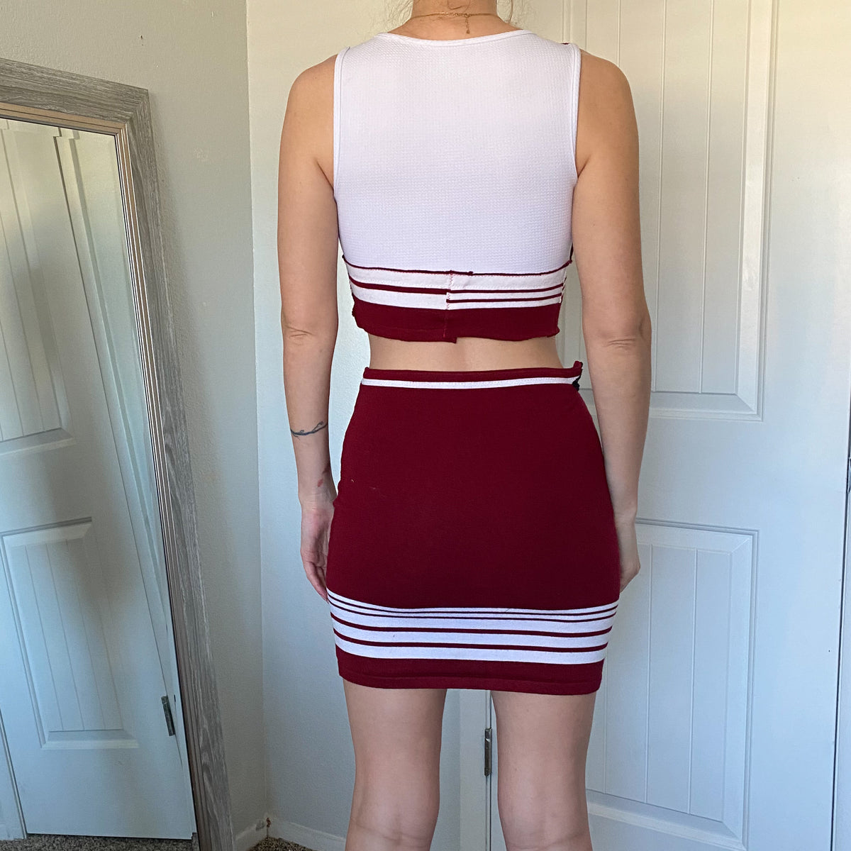 The back view of a woman in a red and white skirt.