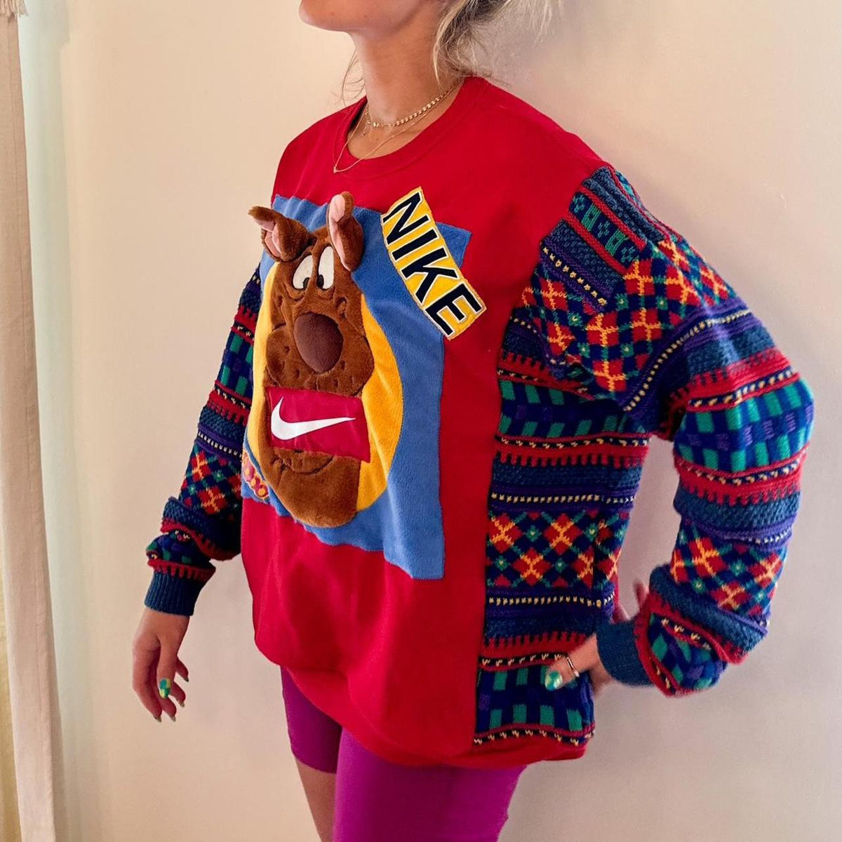 A woman wearing a sweater with a nike dog on it.