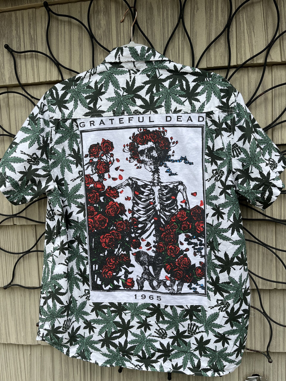 a shirt with a skeleton and flowers on it.