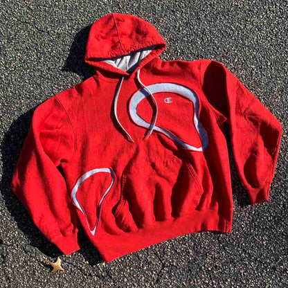 a red hoodie laying on the ground.