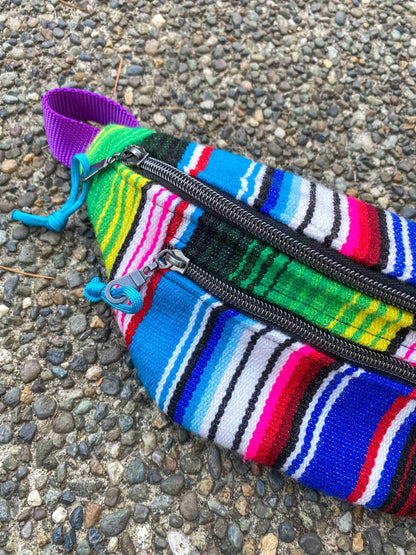 a multicolored striped purse laying on the ground.