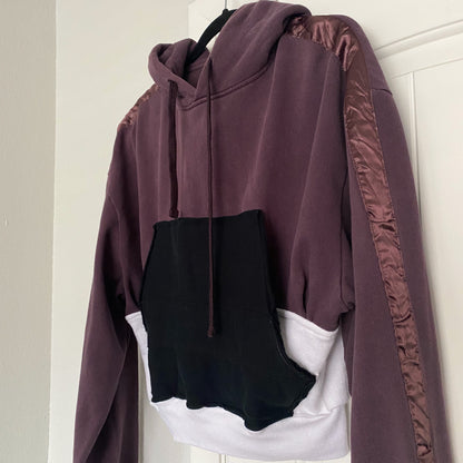 A purple hoodie hanging on a door.