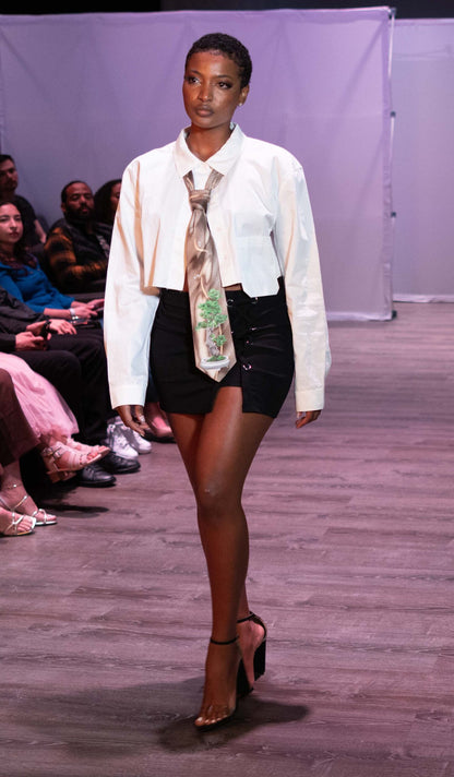 A woman walking down a runway wearing a Hand-painted bonsai tree and dragonflies silk tie.