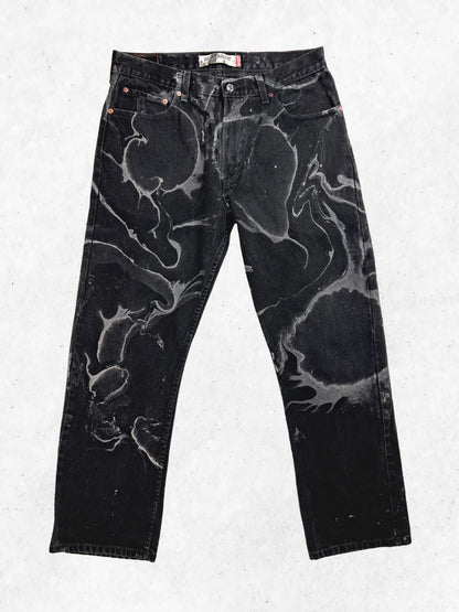 A pair of black jeans with black paint on them.
