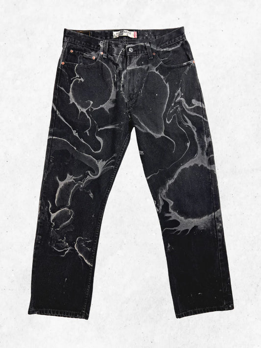 A pair of black jeans with black paint on them.