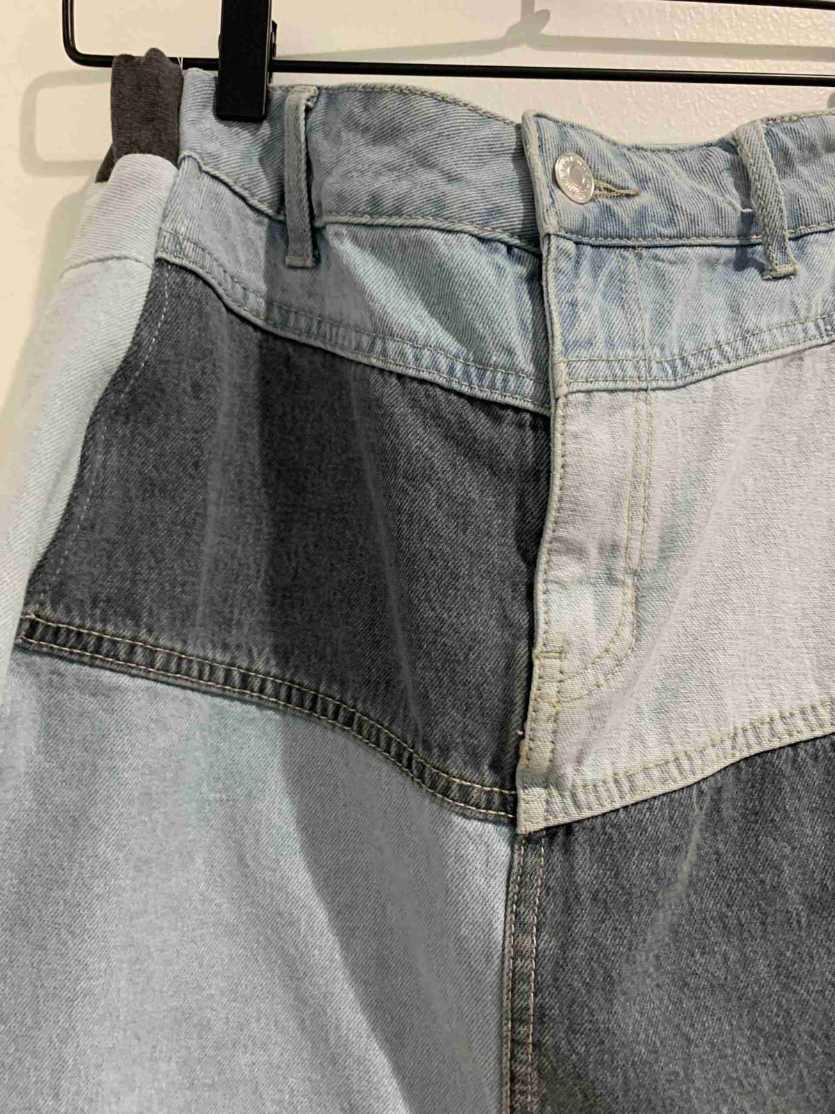 a pair of jeans hanging on a clothes rack.