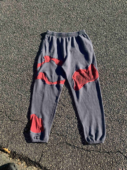 a pair of gray and red pants laying on the ground.