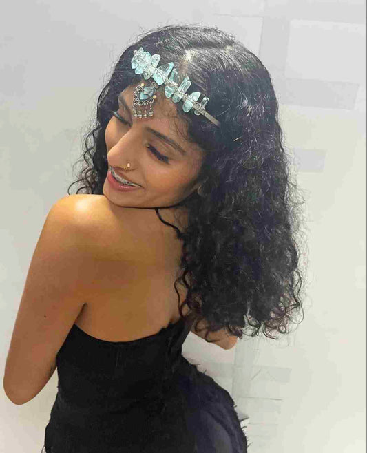 a woman in a black dress wearing a tiara.